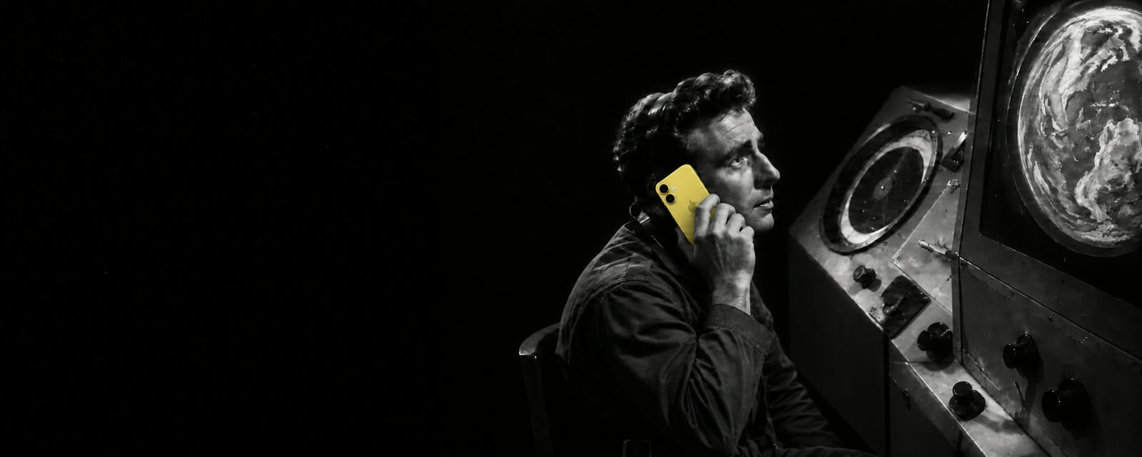 A mission-control operator taking a call on a yellow iPhone
